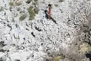 This photo provided by the U.S. Coast Guard shows three Cuban nationals being rescued from a deserted island between Florida and Cuba, Monday, Feb. 9, 2021. They waved flags to catch the attention of a Coast Guard helicopter crew that flew over the island while on a routine mission Monday. (U.S. Coast Guard via AP)
