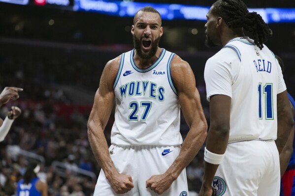 Minnesota Timberwolves center Rudy Gobert, center, reacts with center Naz Reid after drawing an and-one call during the second half of an NBA basketball game against the Los Angeles Clippers, Monday, Feb. 12, 2024, in Los Angeles. (AP Photo/Ryan Sun)