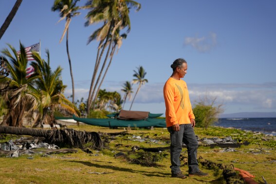 Ekolu Lindsey, who lost the waterfront home where his family has lived for five generations during the August 2023 wildfires, stands for a photo on Saturday, July 6, 2024, in Lahaina, Hawaii. Lindsey is living at a friend’s place on Oahu. He couldn’t find anything in Lahaina for less than $4,000 a month. He returns regularly to Maui to help restore native forests, a focus of the nonprofit his father founded, Maui Cultural Lands. (AP Photo/Lindsey Wasson)
