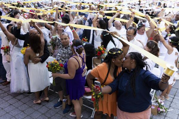 Couples, whose weddings were cancelled or diminished during the COVID-19 pandemic, participate in a symbolic multicultural ceremony at Damrosch Park, Sunday, July 10, 2022, in New York. The evening culminated with a reception on the dance floor at The Oasis and is a part of Lincoln Center's "Summer for the City."  (AP Photo/Julia Nikhinson)