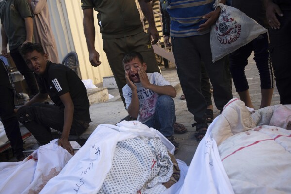 Palestinians mourn relatives killed in the Israeli bombardment of the Gaza Strip, in front of the morgue in Deir al Balah, Tuesday, Oct. 31, 2023. ( AP Photo/Fatima Shbair)