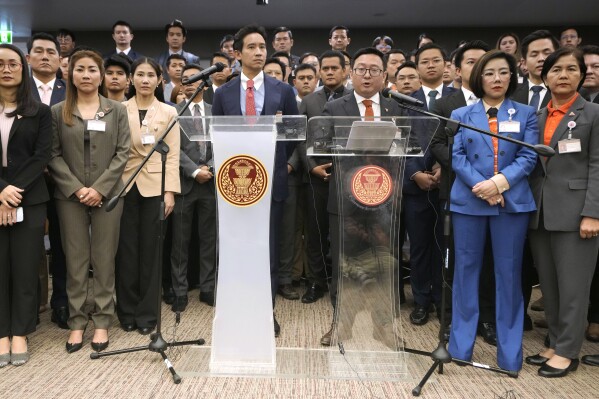 FILE - Move Forward party's leader Chaithawat Tulathon, center right, with its former leader Pita Limjaroenrat, center left, talks to reporters during a news conference at parliament in Bangkok, Thailand, on Jan. 31, 2024. Thailand’s Election Commission on Tuesday, March 12, said it will seek the dissolution of the progressive Move Forward party which won last year's general election after a court ruled that the party’s proposal to amend a royal anti-defamation law was unconstitutional. (AP Photo/Sakchai Lalit, File)