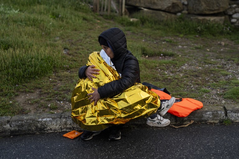 A woman and a child, both Kurdish migrants, rest after a failed attempt to reach the United Kingdom by boat, as they were discovered by the police in Ambleteuse, in northern France, on Sunday, May 19, 2024. (AP Photo/Bernat Armangue)