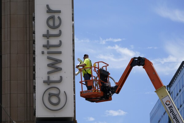 FILE - A workman removes a character from a sign on the Twitter headquarters building in San Francisco, Monday, July 24, 2023. Elon Musk may want to send “tweet” back to the birds, but the ubiquitous term for posting on the site he now calls X is here to stay, at least for now. For one, the word is still plastered all over the website formerly known as Twitter. Write a post, you still need to press a blue button that says “tweet” to publish it. To repost it, you still tap “retweet.” (AP Photo/Godofredo A. Vásquez, File)