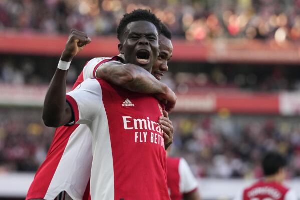 Arsenal's Bukayo Saka, front, celebrates after scoring his side's third goal during the English Premier League soccer match between Arsenal and Tottenham Hotspur at the Emirates stadium in London, Sunday, Sept. 26, 2021. (AP Photo/Frank Augstein)