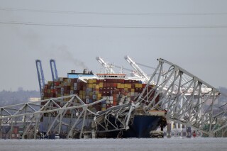 A container ship rests against wreckage of the Francis Scott Key Bridge on Tuesday, March 26, 2024, as seen from Pasadena, Md. Social media users are misrepresenting a 2022 video as footage of the Baltimore bridge's collapse. (AP Photo/Mark Schiefelbein)