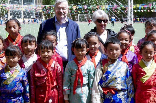 
              In this photo taken May 22, 2019, and released by the U.S. Embassy in Beijing, U.S. Ambassador to China Terry Branstad and his wife Christine pose for a group photo with schoolchildren as he visits an elementary school in Lhasa in western China's Tibet Autonomous Region. The U.S. ambassador to China made a rare visit to Tibet this week to meet local officials and raise concerns about restrictions on Buddhist practices and the preservation of the Himalayan region's unique culture and language. (U.S. Mission to China via AP)
            