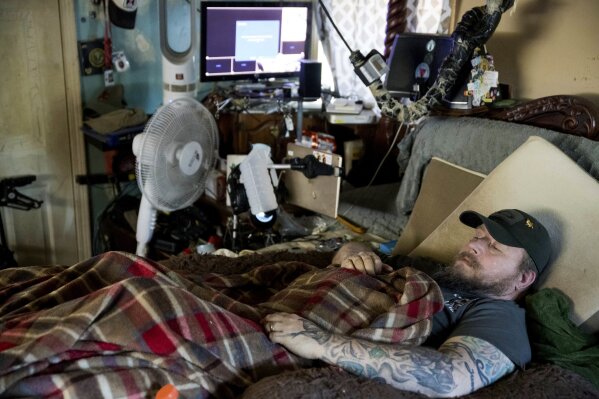 
              In this Friday, Nov. 16, 20158 photo, Jim Taft watches The History Channel from the confines of his bed at his home in West Columbia, S.C. Taft has experienced debilitating health issues after a neurosurgeon implanted Boston Scientific's Precision spinal cord stimulator in his back in 2014. (AP Photo/Sean Rayford)
            