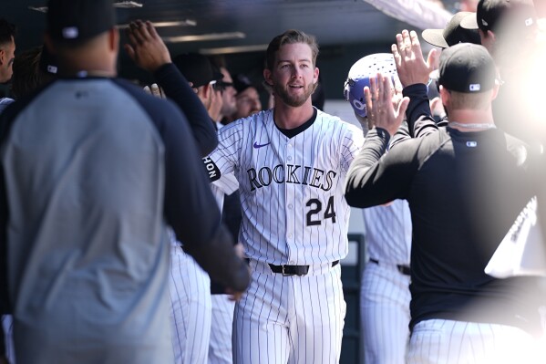 Colorado Rockies' Ryan McMahon is congratulated after hitting a two-run home run off Philadelphia Phillies starting pitcher Ranger Suárez in the first inning of a baseball game, Sunday, May 26, 2024, in Denver. (AP Photo/David Zalubowski)