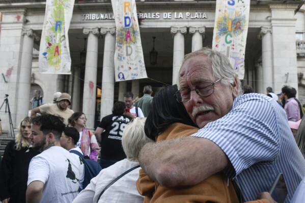 The relative of a victim embraces a person after the reading of the verdict for former police officers on trial for crimes against humanity during the 1976-1983 dictatorship, in La Plata, Argentina, Tuesday, March 26, 2024. The officers were convicted on Tuesday of torturing over 20 pregnant women and stealing at least 10 babies, seven of which have been identified and recovered. Hundreds of babies were abducted during the Argentine dictatorship. (AP Photo/Gustavo Garello)