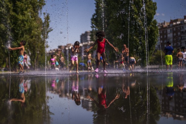 FILE - Children cool off at an urban beach at Madrid Rio park in Madrid, Spain, June 26, 2023. Spain this year recorded its third hottest summer since official records began 62 years ago, authorities said Thursday, with temperatures peaking at 46.8 degrees Celsius as the country's severe drought dragged on. The average summer temperature was 1.3 degrees C above normal, the Spanish weather agency AEMET said. (AP Photo/Manu Fernandez, Fie)