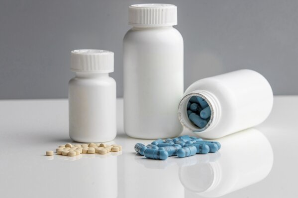 This November 2020 photo provided by McMaster University shows 75mg aspirin pills, left, and Polycaps, pills from India-based Cadila Pharmaceuticals that contains one cholesterol and three blood pressure medicines, used in the International Polycap Study 3 (TIPS-3). On Friday, Nov. 13, 2020, researchers say the cheap, daily pill taken with low-dose aspirin can cut the risk of heart attacks, strokes and heart-related deaths by nearly one third. (Georgia Kirkos/McMaster University via AP)