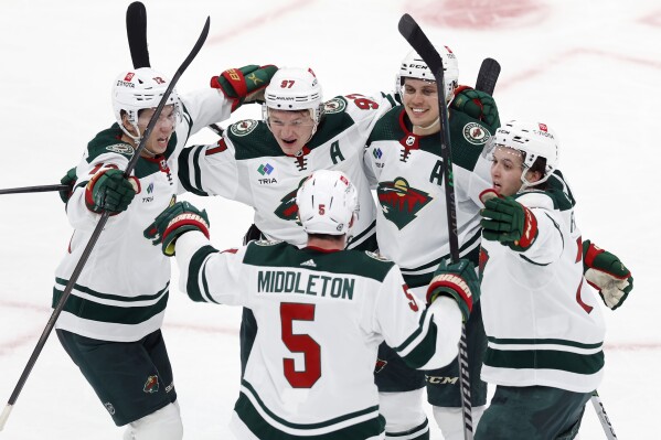 Minnesota Wild's Kirill Kaprizov (97) celebrates his goal with teammates Jake Middleton (5), Matt Boldy (12), Joel Eriksson Ek, second from right, and Brock Faber, right, during the third period of an NHL hockey game against the Boston Bruins, Tuesday, Dec. 19, 2023, in Boston. (AP Photo/Michael Dwyer)