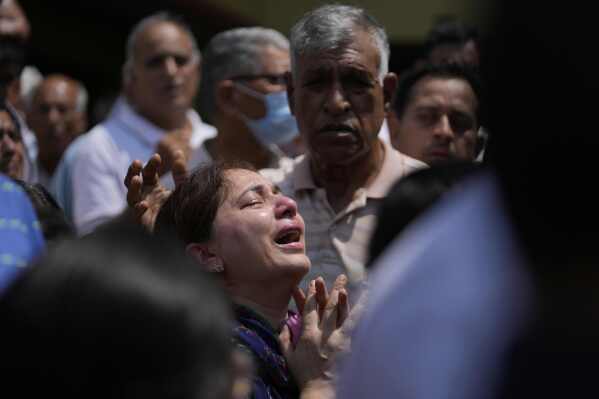 A relative mourns at the funeral of Raj Thapa, a senior bureaucrat who was killed in Pakistani shelling in Rajouri, in Jammu, India, Sunday, May 11, 2025. (AP Photo/Channi Anand)