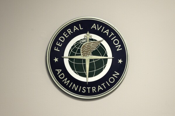 FILE - A Federal Aviation Administration sign hangs in the tower at John F. Kennedy International Airport in New York, March 16, 2017. U.S. regulators are requiring immediate inspections and possible repairs to Pratt & Whitney engines on some Airbus passenger jets because of a risk that parts could fail and damage the planes during flight. The FAA said Friday, Aug. 18, 2023, that it acted after further analysis of an engine shutdown last December that required pilots of an Airbus A320neo to abort a takeoff. (AP Photo/Seth Wenig, File)
