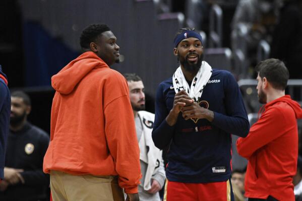 Injured New Orleans Pelicans forward Zion Williamson, left, talks with forward Naji Marshall, second from right, during a timeout in the second half of an NBA basketball game against the Washington Wizards, Monday, Jan. 9, 2023, in Washington. (AP Photo/Terrance Williams)