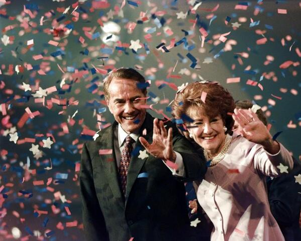 FILE - Bob Dole and his wife Elizabeth wave from the podium on the floor of the Republican National Convention in San Diego,  Aug. 15, 1996, as confetti falls after Dole accepted the Republican presidential nomination. Bob Dole, who overcame disabling war wounds to become a sharp-tongued Senate leader from Kansas, a Republican presidential candidate and then a symbol and celebrant of his dwindling generation of World War II veterans, has died. He was 98. His wife, Elizabeth Dole, posted the announcement Sunday on Twitter (AP Photo/J. Scott Applewhite, File)