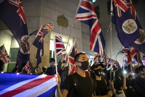 Demonstrators hold British flags during a rally outside of the British Consulate in Hong Kong, Wednesday, Oct. 23, 2019. Some hundreds of Hong Kong pro-democracy demonstrators have formed a human chain at the British consulate to rally support for their cause from the city's former colonial ruler. (AP Photo/Mark Schiefelbein)