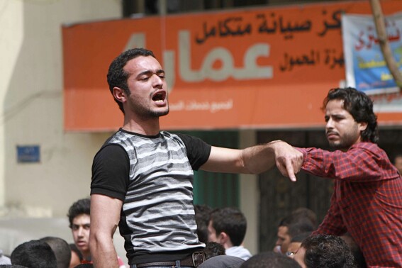 FILE - Activist Ahmed Douma, left, chants slogans as activist Khaled ElSayed, right, supports him, during a march to Tahrir Square demanding the prosecution of members of former President Hosni Mubarak's regime in Cairo, Egypt, April 1, 2011. The leading Egyptian activist, behind the 2011 uprising that toppled longtime autocrat Hosni Mubarak, walked free from prion Saturday, Aug. 19, 2023, following a presidential pardon after spending nearly 10 years behind bars. (AP Photo/Sarah Carr, File)