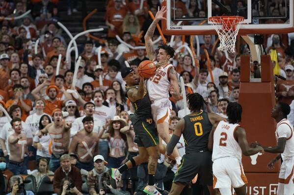 Baylor guard James Akinjo, left, drives to the basket against Texas forward Christian Bishop (32) during the second half of an NCAA college basketball game, Monday, Feb. 28, 2022, in Austin, Texas. (AP Photo/Eric Gay)