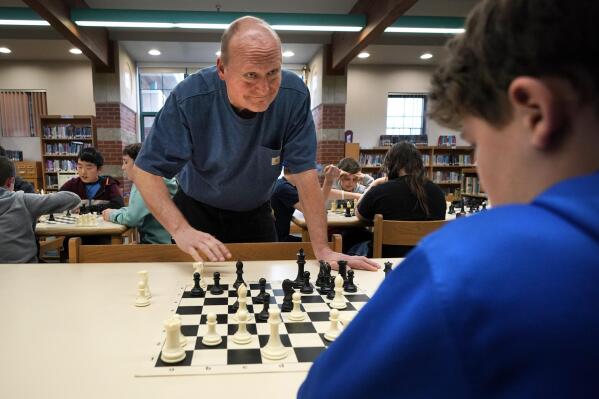 Custodian and chess coach David Bishop challenges 6th-grader Owen Isenhour during after-school practice, Tuesday, April 25, 2023, in Hampden, Maine. Under Bishop's tutelage, the Reeds Brook Middle School chess team has gained national recognition. (AP Photo/Robert F. Bukaty)