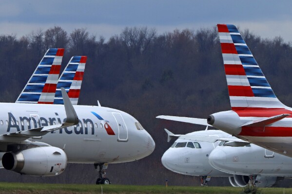 FILE - American Airlines planes sit stored at Pittsburgh International Airport on March 31, 2020, in Imperial, Pa. A jury is deciding that a clothing company should pay more than $1 million to four American Airlines flight attendants who blame chemicals used in the production of their uniforms for causing ailments including rashes and breathing difficulty. Lawyers for the crew members say they represent more than 400 other flight attendants who are making the same claims. Some flight attendants say they had reactions to new uniforms that American gave them in 2016. They sued Twin Hill Acquisition Company and its Tailored Brands division. (AP Photo/Gene J. Puskar, File)