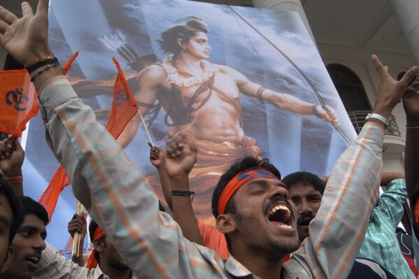 FILE - Standing before a poster of the Hindu deity Ram, a Vishwa Hindu Parishad (World Hindu Council) member shouts slogans during a rally to protest against the raid on a Hindu temple in northern India, in Gauhati, India, July 7, 2005. While the slogan "Jai Sri Ram," or "Hail Lord Ram," has become a political battle cry for Hindu nationalists, "Ram-Ram" remains a popular way of greeting across rural India. (AP Photo/Gautam Singh, File)