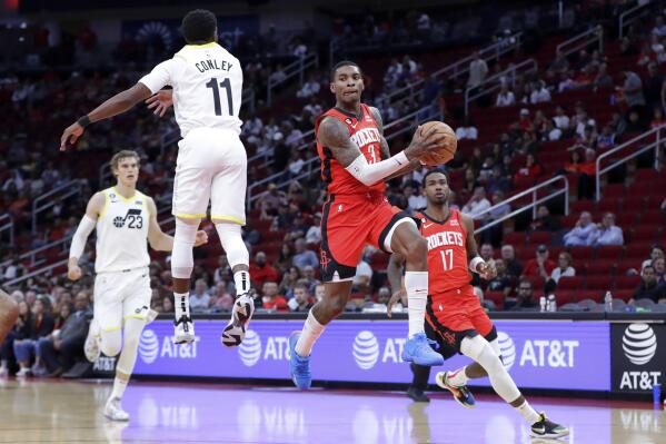 Houston Rockets guard Kevin Porter Jr. jumps to pass the ball as Utah Jazz guard Mike Conley (11) defends while forward Lauri Markkanen (23) and forward Tari Eason (17) look on during the first half of an NBA basketball game, Monday, Oct. 24, 2022, in Houston. (AP Photo/Michael Wyke)