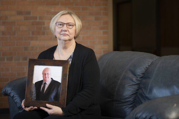 
              Nancy Buchholz holds her husband Jeff's picture, who died six weeks after being diagnosed with cancer this spring. Nancy got Bind coverage through her employer, Dove Healthcare and the only bill she had to pay for his hospital stay was the $1,900 copayment laid out in the new insurance plan. (AP Photo/Stacy Bengs)
            
