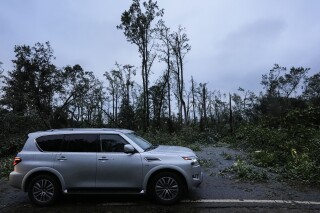 FILE - Vehicles move slowly around trees that have fallen after Hurricane Helene moved through the area, Sept. 27, 2024, in Valdosta, Ga. (AP Photo/Mike Stewart, File)