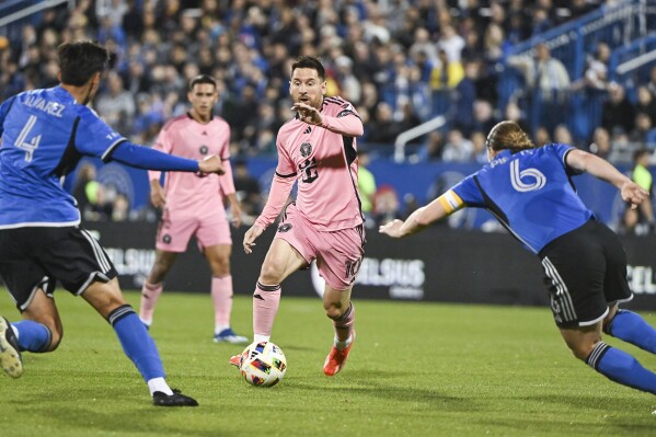 Inter Miami's Lionel Messi (10) pushes forward as CF Montreal's Fernando Alvarez (4) and Samuel Piette (6) defend during the first half of an MLS soccer match Saturday, May 11, 2024, in Montreal. (Graham Hughes/The Canadian Press via AP)