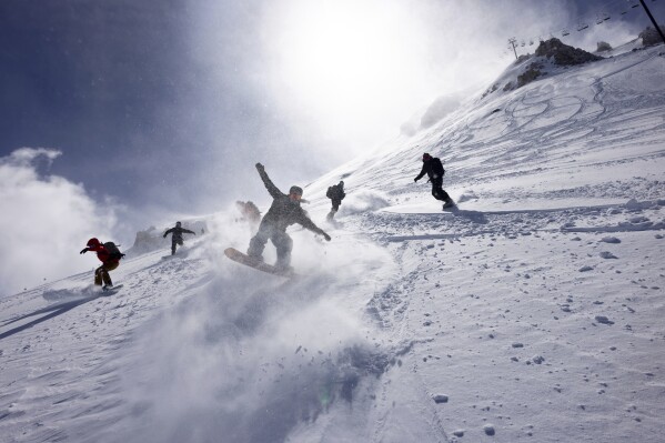 In this photo provided by Mammoth Lakes Tourism, people snowboard at the Mammoth Mountain Ski Area in Mammoth Lakes, Calif., Wednesday, Feb. 21, 2024. (Andrew Miller/Mammoth Mountain via AP)
