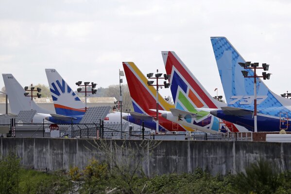 FILE - In this April 20, 2020, file photo, a line of Boeing 737 MAX jets sit parked on the airfield adjacent to a Boeing production plant in Renton, Wash. Boeing Co. has said it will outsource a significant amount of information technology work to Dell starting in April 2021, including support of cloud services, databases and information technology. The Seattle Times reported that Susan Doniz, vice president for information technology and data analytics for Boeing, told employees Thursday, Feb. 4 that the eliminated jobs represent about 10% of the company's IT staff. (AP Photo/Elaine Thompson, File)