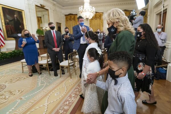 First lady Jill Biden, walks in the East Room with little caregivers, standing in front from left to right, Gabby and Eva Rodriguez, and Mason, during a ceremony at the White House honoring children in military and veteran caregiving families, Wednesday, Nov. 10, 2021. (AP Photo/Manuel Balce Ceneta)