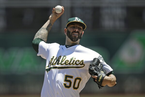FILE - In this July 28, 2019, file photo, Oakland Athletics pitcher Mike Fiers works against the Texas Rangers in the first inning of a baseball game, in Oakland, Calif. When future generations are documenting baseball history, Mike Fiers will surely be remembered as one of the game's most significant figures. Not necessarily for what he did on the field, though tossing a pair of no-hitters is certainly a worthy achievement.(AP Photo/Ben Margot, File)