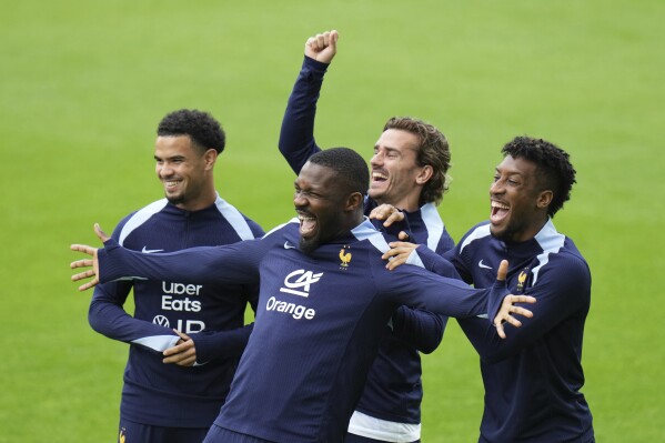 France's Warren Zaire-Emery, left, France's Marcus Thuram, second left, France's Antoine Griezmann, second right, and France's Kingsley Coman gesture during a training session in Paderborn, Germany, Saturday, June 15, 2024. France will play against Austria during their Group D soccer match at the Euro 2024 soccer tournament on June 17. (AP Photo/Hassan Ammar)