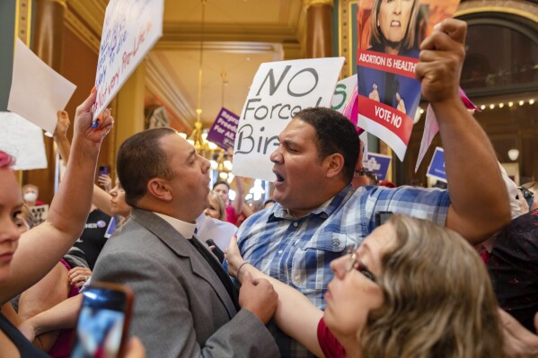 FILE - Pastor Michael Shover of Christ the Redeemer Church in Pella, left, argues with Ryan Maher, of Des Moines, as protestors voice opposition to a new ban on abortion after roughly six weeks of pregnancy introduced by Republican lawmakers in a special session in Des Moines, Iowa, on July 11, 2023. An Iowa judge on Friday, July 14, will consider a request to postpone the state’s new ban on most abortions, just as Gov. Kim Reynolds is scheduled to sign the measure into law in front of 2,000 conservative Christians barely a mile away. (Zach Boyden-Holmes/The Des Moines Register via AP, File)