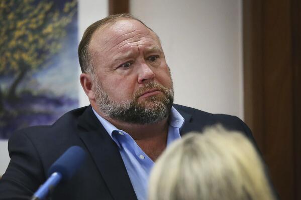 Conspiracy theorist Alex Jones attempts to answer questions about his emails asked by Mark Bankston, lawyer for Neil Heslin and Scarlett Lewis, during trial at the Travis County Courthouse in Austin, Wednesday Aug. 3, 2022. Jones testified Wednesday that he now understands it was irresponsible of him to declare the Sandy Hook Elementary School massacre a hoax and that he now believes it was “100% real." (Briana Sanchez/Austin American-Statesman via AP, Pool)