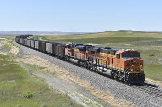 FILE - A BNSF railroad train hauling carloads of coal from the Powder River Basin of Montana and Wyoming is seen east of Hardin, Mont., on July 15, 2020. BNSF railroad's two biggest unions that represent 17,000 workers won't be able to go on strike over a new attendance policy they say would penalize employees for missing work for any reason, a federal judge ruled Tuesday, Jan. 25, 2022. (AP Photo/Matthew Brown, File)