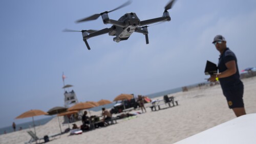 Cary Epstein, lifeguarding supervisor, operates a drone during takeoff for a shark patrol flight at Jones Beach State Park, Thursday, July 6, 2023, in Wantagh, N.Y. Drones are sweeping over the ocean off the coast of New York’s Long Island to patrol the waters for any danger possibly lurking. (AP Photo/John Minchillo)