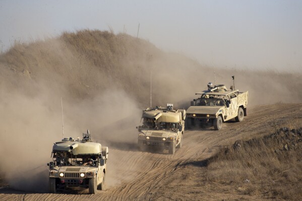 FILE - Israeli soldiers drive military vehicles during an exercise in the Israeli-controlled Golan Heights near the border with Syria, Tuesday, Aug. 4, 2020. (AP Photo/Ariel Schalit, File)