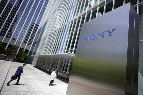 FILE - People walk past the headquarters of Sony Corp. in Tokyo, on May 10, 2022. Sony’s April-June profit slipped 17% from a year earlier, as worries grew about revenue damage from a strike in the movies sector, the Japanese electronics and entertainment company said Wednesday, Aug. 9, 2023. (AP Photo/Eugene Hoshiko, File)