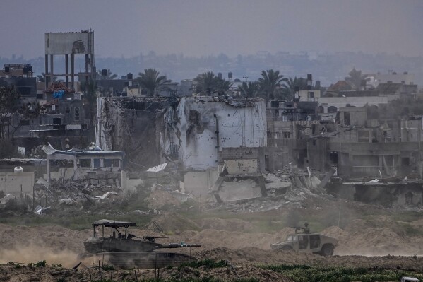 FILE - Israeli soldiers operate inside the Gaza Strip, as seen from southern Israel, on Feb. 13, 2024. The latest proposal for a cease-fire in Gaza has the support of the United States and most of the international community, but Hamas has not fully embraced it, and neither, it seems, has Israel.(AP Photo/Ariel Schalit, File)