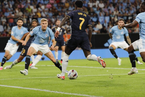 Real Madrid's Vinicius Junior, center, kicks the ball during the Spanish La Liga soccer match between Celta Vigo and Real Madrid at the Balaidos stadium in Vigo, Spain, Friday, Aug. 25, 2023. (AP Photo/Lalo R. Villar)