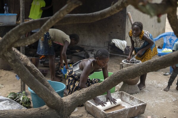 A family bakes bread in their village of Kinkazi, which has been impacted by oil drilling, outside Moanda, Democratic Republic of the Congo, Sunday, Dec. 24, 2023. (AP Photo/Mosa'ab Elshamy)