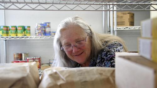 Rose Carney is shown organizing supplies at the food pantry at Harvest Christian Fellowship Church in Eagle River, Alaska, on April 17, 2023. Carney and thousands of Alaskans who depend on government assistance have not received food stamps for months, exacerbating a hunger crisis. (AP Photo/Mark Thiessen)