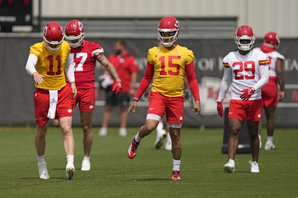 Kansas City Chiefs quarterback Patrick Mahomes (15) stretches with teammates during the NFL football team's organized team activities Wednesday, May 22, 2024, in Kansas City, Mo. (AP Photo/Charlie Riedel)