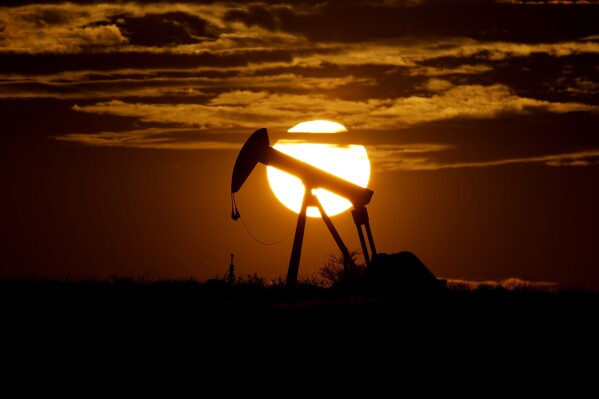 FILE - The sun sets behind an idle pump jack near Karnes City, Texas, April 8, 2020. The U.S. Securities and Exchange Commission paused on Thursday, April 4, 2024, the implementation of its new climate disclosure rule while it defends the regulation in court. (AP Photo/Eric Gay, File)