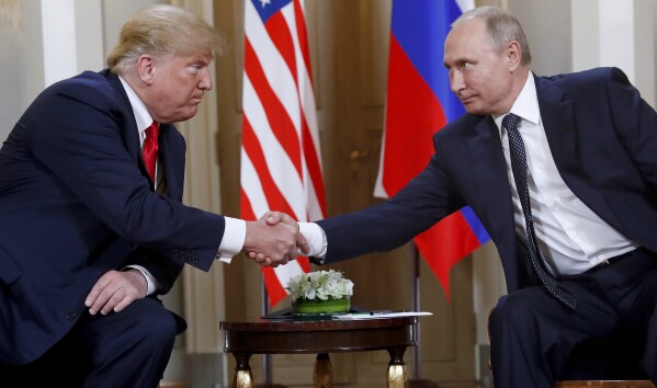 President Donald Trump, left, and Russian President Vladimir Putin shake hands at the beginning of a meeting at the Presidential Palace in Helsinki, Finland, July 16, 2018. (AP Photo/Pablo Martinez Monsivais, File)