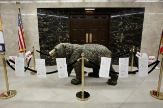 In another coronavirus precaution, California officials cordoned off the sculpture of a bear outside the office of Gov. Gavin Newsom, at the Capitol in Sacramento, Calif., Wednesday, March 11, 2020. The sculpture was purchased by former Gov. Arnold Schwarzenegger and was quickly nicknamed "Bacteria Bear," after it became a favorite backdrop for photographs and selfies by school children and other Capitol visitors. (AP Photo/Rich Pedroncelli)